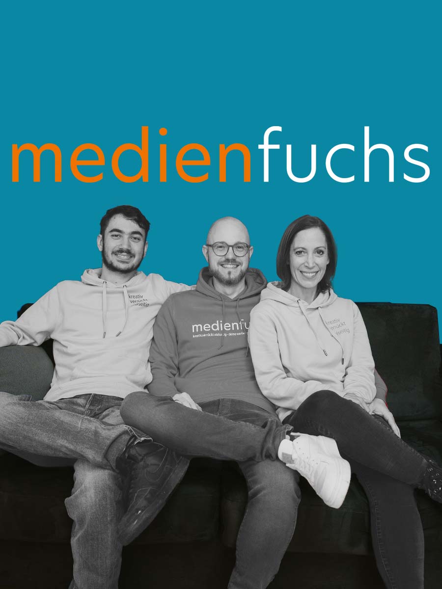 Das Bild zeigt das ganze Team von medienfuchs auf einem Sofa sitzend